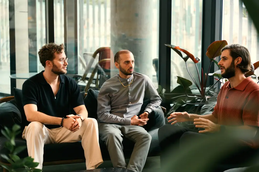 Three people in conversation on a sofa