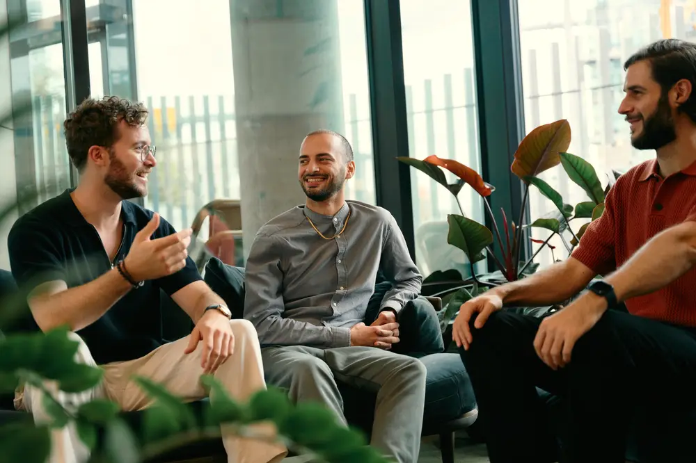 Three people in conversation on a sofa